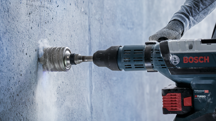 Object #200476152: 3065450_app_web_1 Worker wearing safety equipment drills a round hole into a concrete wall.