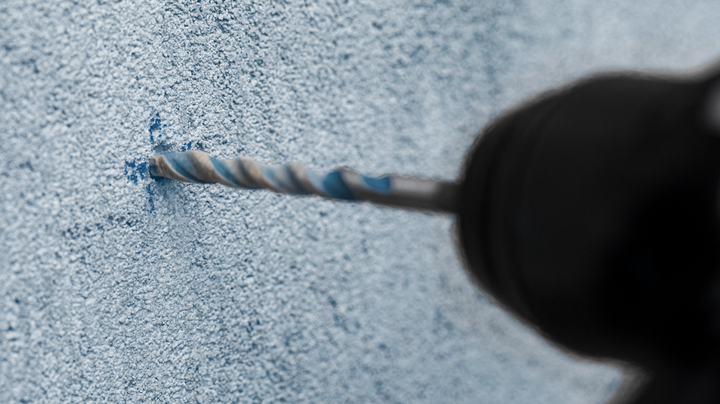 Object #200360546: 2793184_web_002 Rotary hammer drilling into a textured concrete wall.